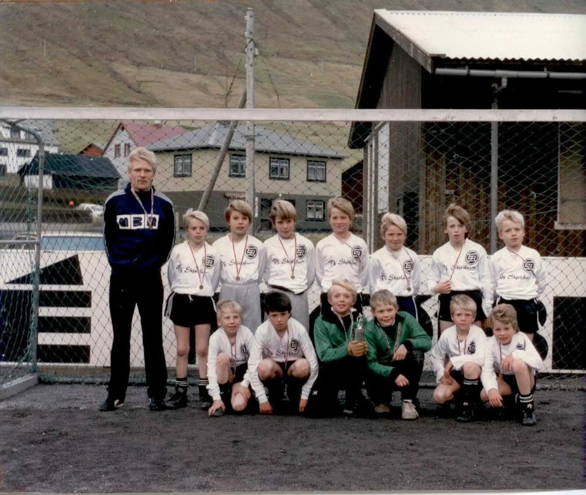 EB smápiltar 1986. Aftastir f.v.: Páll Guðlaugsson, venjari, Marius Fríðálvur Joensen, Allan Dahl Kristensen, Brian Dahl Kristensen, Jákup Martin Joensen, Dan Joensen, Jónsvein Sverrason Joensen og Alfred Jacobsen. Fremstir f.v.: Robert á Stongum, Knút Vesturtún Vesturdal, Ingi Ellingsgaard, Jens Sørensen, Janus í Løðini og Jóhann Lützen.