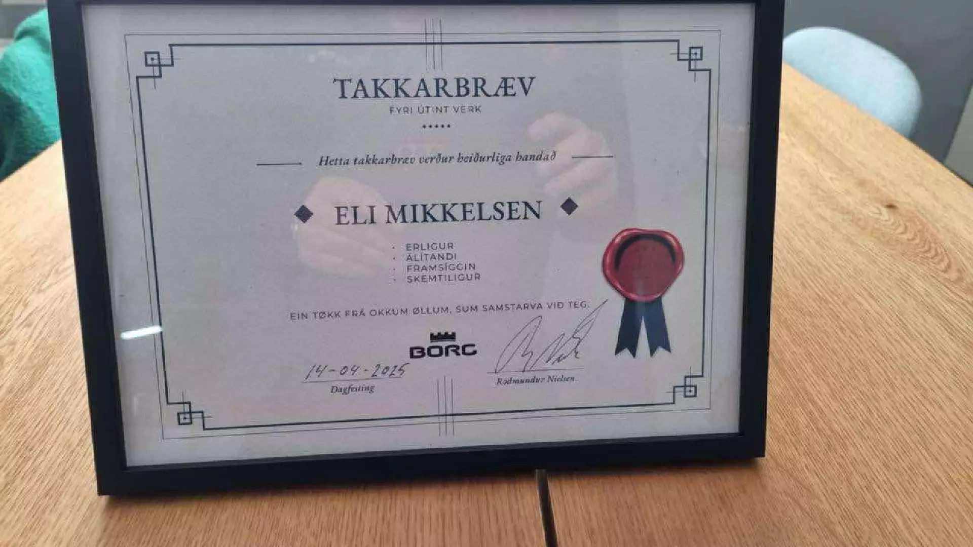 Takkarbrævið sum Rodmund Nielsen handaði Eli Mikkelsen, maskinførara hjá Kanjon fyri útint verk. Fyri hegni og góðan samstarvsvilja. Eli er lesi- og taluveikur, men hevur góð evni at arbeiða og sum maskinførari er hann útmerkaður.