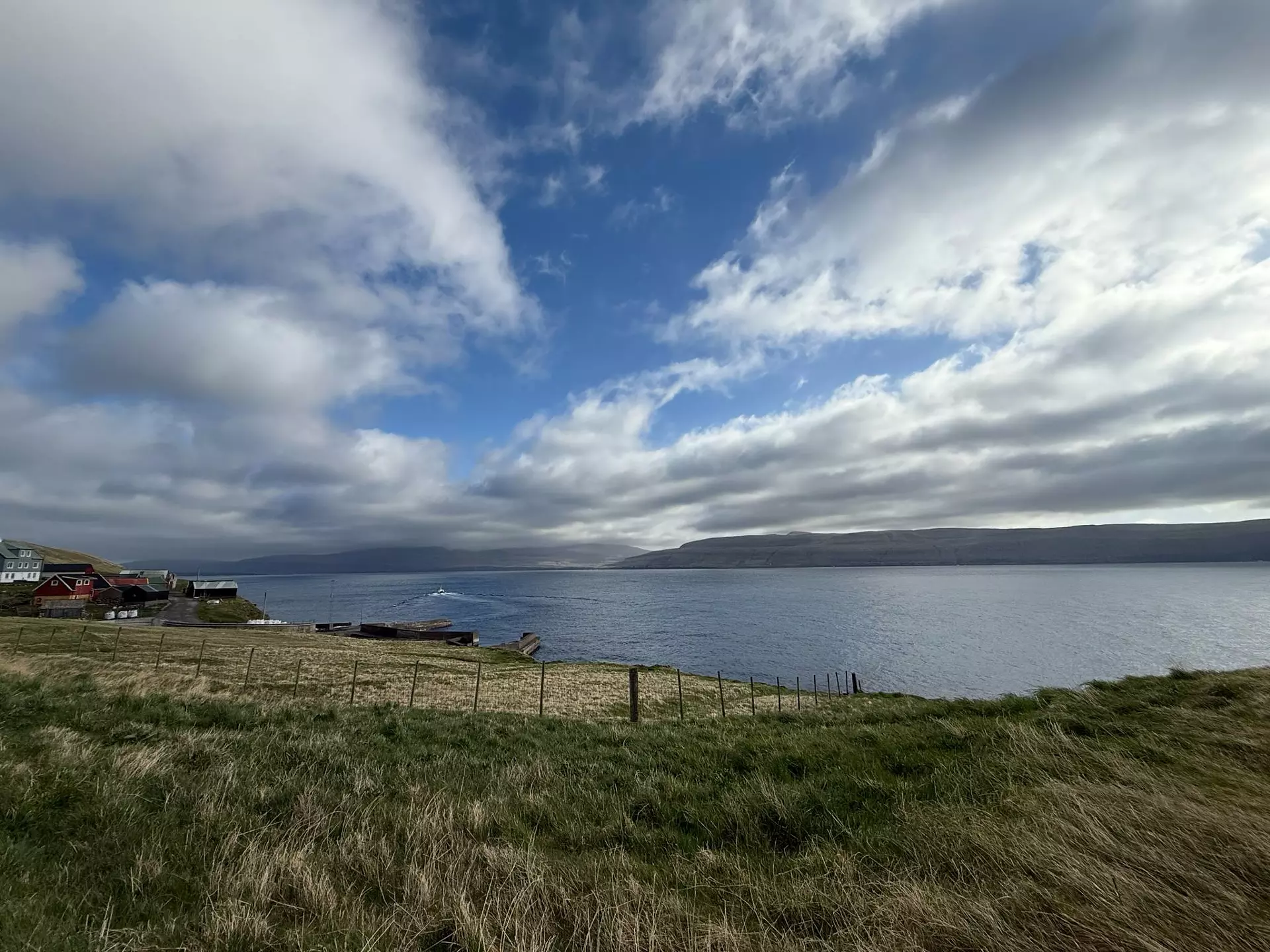 Hálvskýggjað yvir Skúvoyarfirði fyrrapartin hósdagin 8. mai. Lagskýggj (stratus) oman fyri Sandoynna, men tey eru ikki tjúkk, og einki avfall dettur niðurúr. Hátrýstveður. Miðjan á hátrýstinum var yvir Skotlandi hendan morgunin, og vit høvdu eitt veikt og lýtt luftrák av útsynningi suðuri. Mynd: Finn Johannessen.