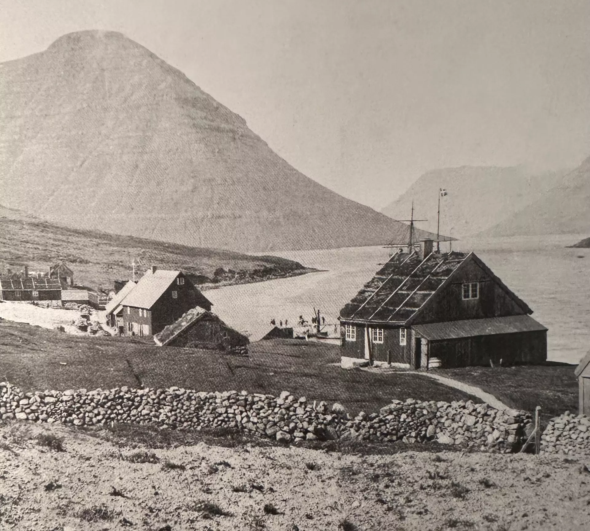 Fremst á myndini til høgru eru tey fyrstu læknahúsini í Klaksvík frá 1872. Húsini í miðjuni eru sýsslumanshúsini frá 1865. Uttanfyri og vinstrumegin myndina eru handilsbyggningarnir úti í Klaksvíkini